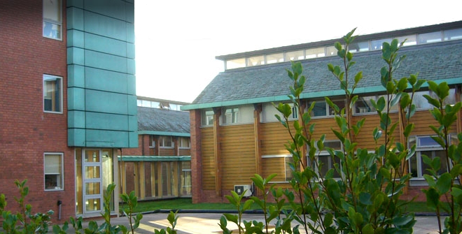 Photograph of a low modern office building surrounded by countryside|