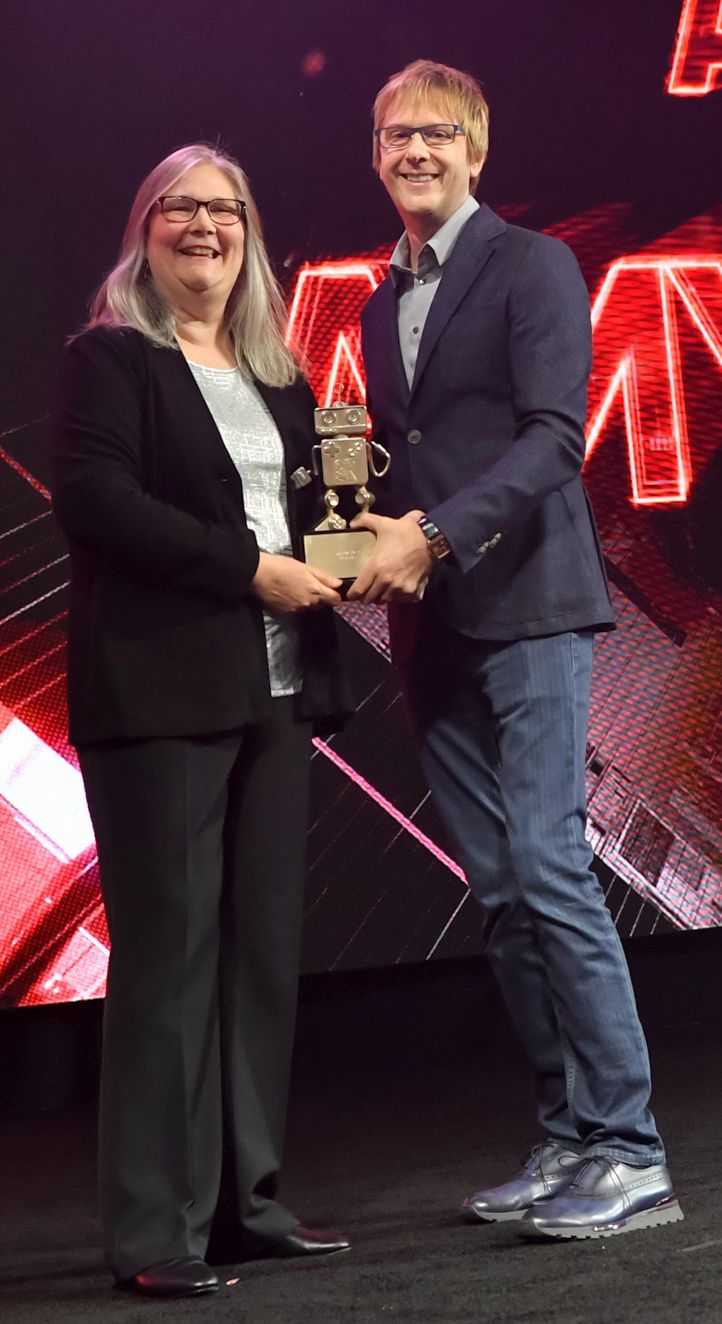 Two people standing together at an awards event in 2019.