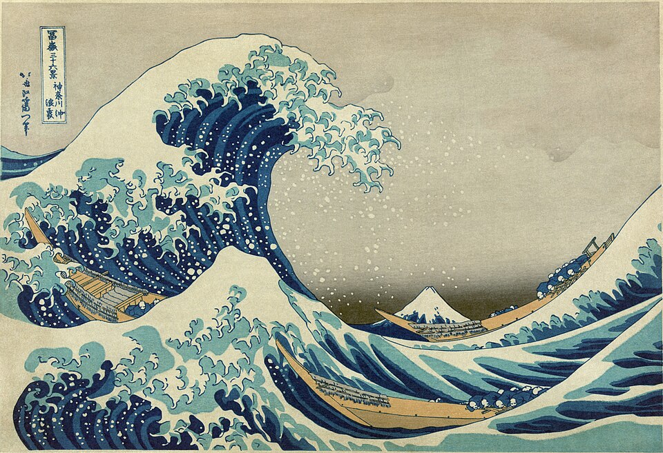 Woodblock print of a large cresting blue wave with boats and Mount Fuji in the distance