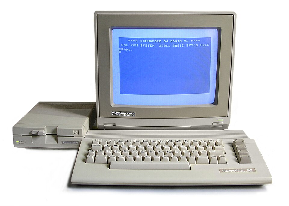 A cream-colored Commodore 64C with disk drive and monitor.