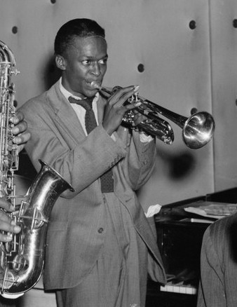 Black-and-white portrait of a young Miles Davis in a suit|