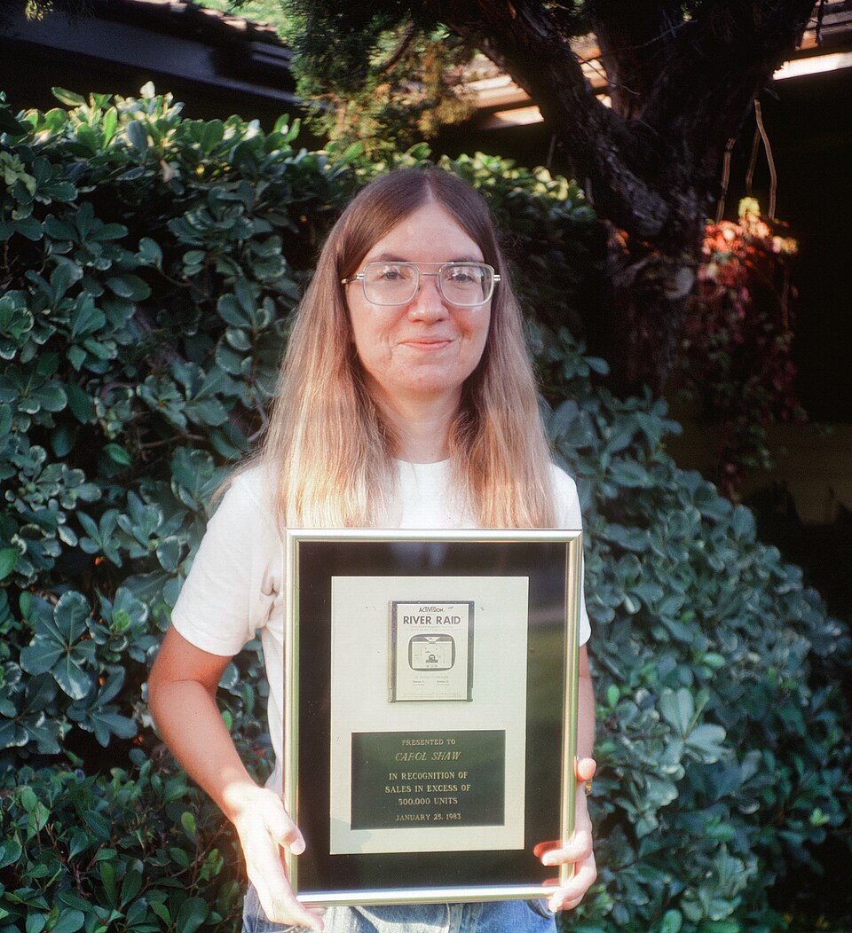 Carol Shaw holding a gold River Raid cartridge|