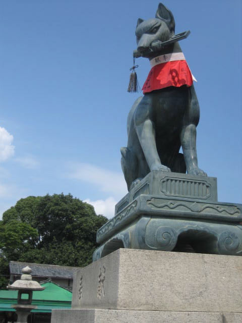 Statue of a fox with a key in its mouth at an Inari shrine gate