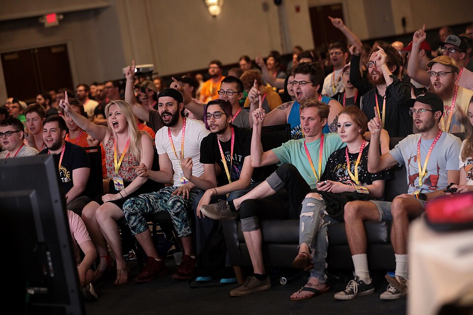 A crowd of seated attendees watching a speedrunning stream at a Games Done Quick event.