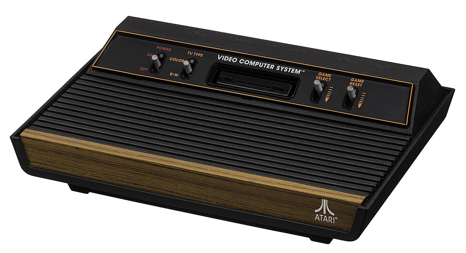 A woodgrain Atari 2600 console with four front switches and an attached joystick controller.