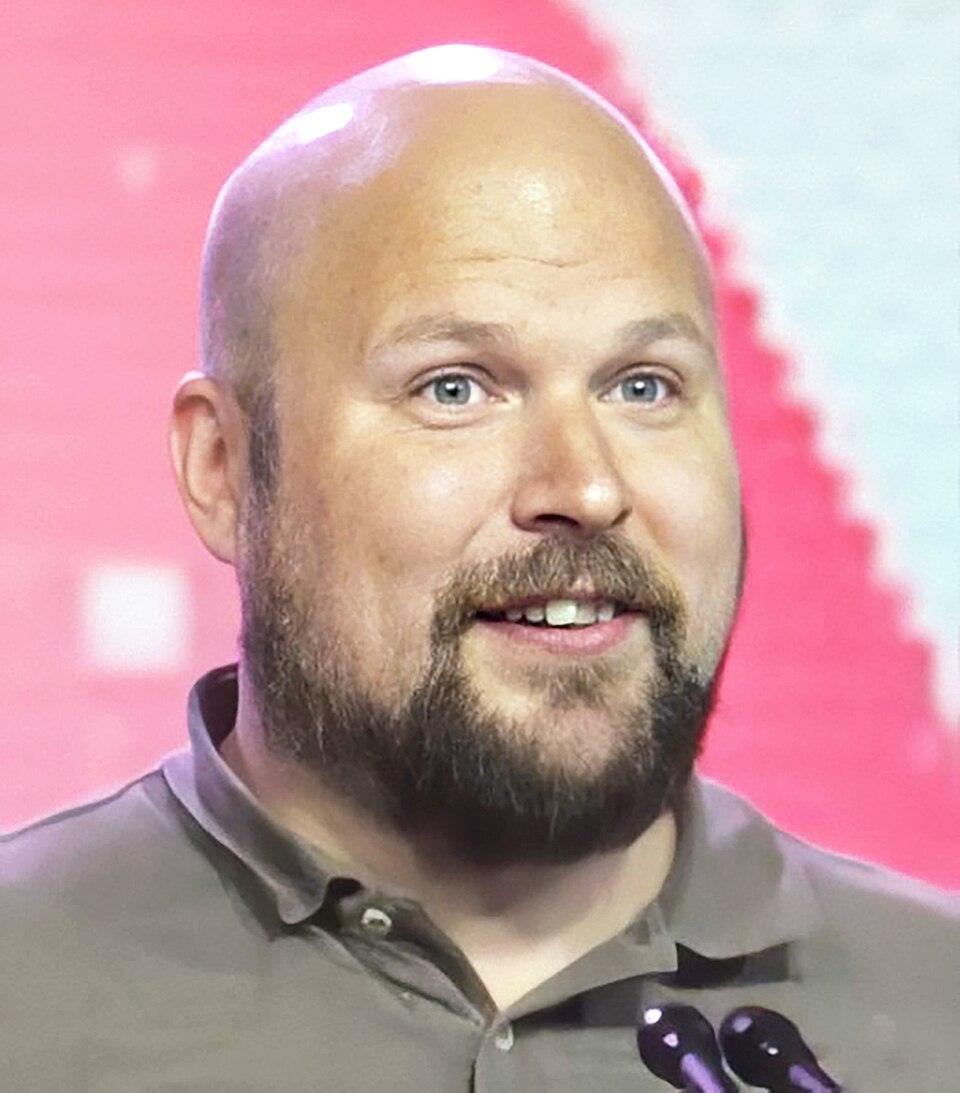 Markus Persson holding an award on stage