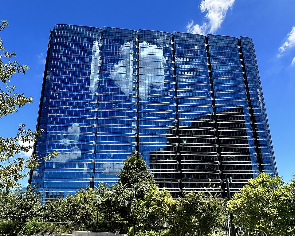 A tall modern glass office tower rising against the sky.